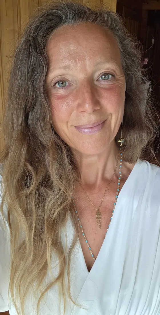 Portret van Ellen in een witte blouse met gouden sieraden, in een houten ruimte