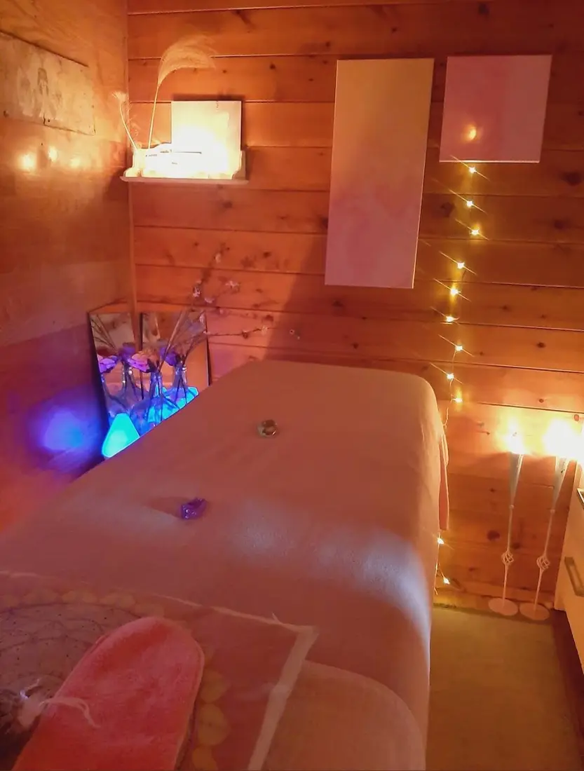 De behandelruimte: een massagetafel met zacht laken, houten wanden en warme lampjes